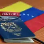 A Venezuelan passport, a bracelet with the inscription that reads "Venezuela," and a small flag of Venezuela over a desk. Photo: File photo.