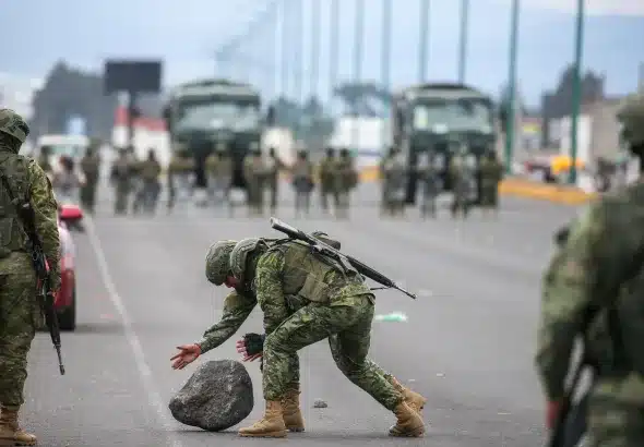 Military removes a stone during protests on Monday, Sep. 20, 2025, in Latacunga, Ecuador. Photo: José Jácome/EFE.