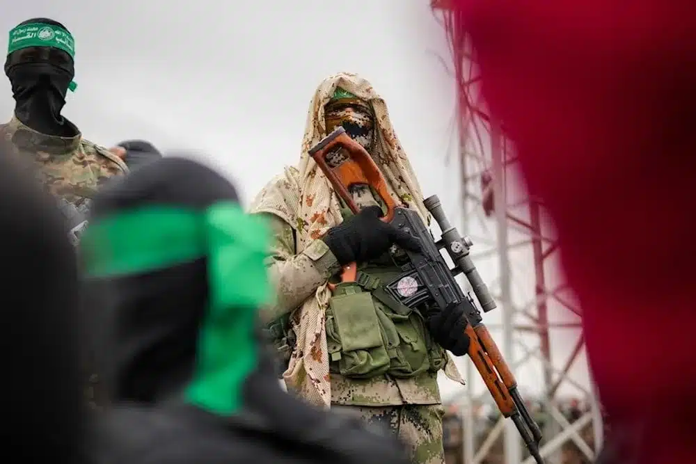 A member of the Al-Qassam Brigades in combat fatigues standing before the ceremony for the handover of Israeli prisoners of war to the Red Cross in Nuseirat, Central Gaza Strip, Saturday, February 22, 2025. Photo: AP.