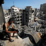 A Palestinian man looks on at the site of an Israeli strike in September 2025 that massively destroyed residential buildings. Photo: Mahmoud Issa/Reuters/file photo.