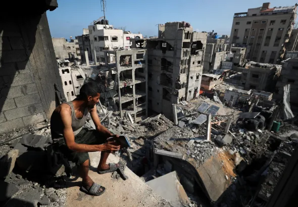 A Palestinian man looks on at the site of an Israeli strike in September 2025 that massively destroyed residential buildings. Photo: Mahmoud Issa/Reuters/file photo.