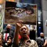 A demonstrator holds a picture of a killed Palestinian child as she chants slogans during a protest in solidarity with journalists in the Gaza Strip organized by journalists outside Egyptâs Press Syndicate in Cairo on August 13, 2025. Photo: Khaled Desouki/AFP.