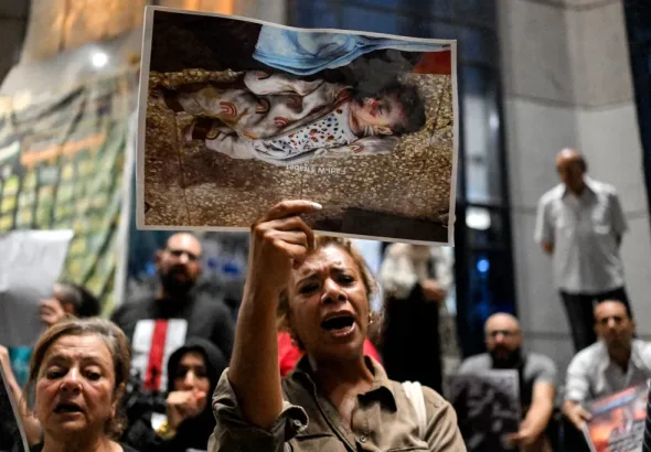 A demonstrator holds a picture of a killed Palestinian child as she chants slogans during a protest in solidarity with journalists in the Gaza Strip organized by journalists outside Egypt’s Press Syndicate in Cairo on August 13, 2025. Photo: Khaled Desouki/AFP.