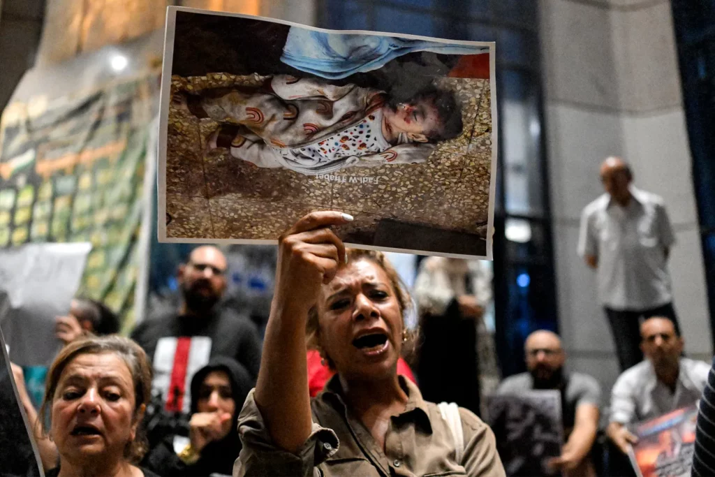A demonstrator holds a picture of a killed Palestinian child as she chants slogans during a protest in solidarity with journalists in the Gaza Strip organized by journalists outside Egypt’s Press Syndicate in Cairo on August 13, 2025. Photo: Khaled Desouki/AFP.