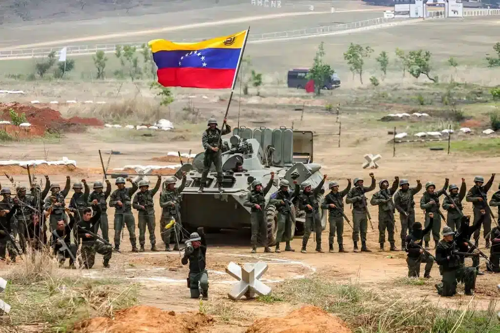 Venezuelan soldiers around a tank on which another soldier waves a Venezuelan flag during a military drill in Cojedes state. Photo: Presidential Press/file photo.