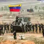 Venezuelan soldiers around a tank on which another soldier waves a Venezuelan flag during a military drill in Cojedes state. Photo: Presidential Press/file photo.