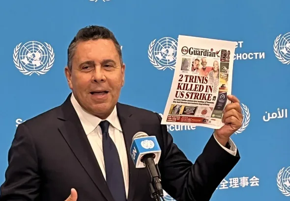 Samuel Moncada, Venezuela’s ambassador to the UN, holds press conference and holds up a picture of front page of T&T Guardian displaying two citizens of Trinidad who were murdered by the last US imperial strike in Caribbean. Photo: X/@elizondogabriel.