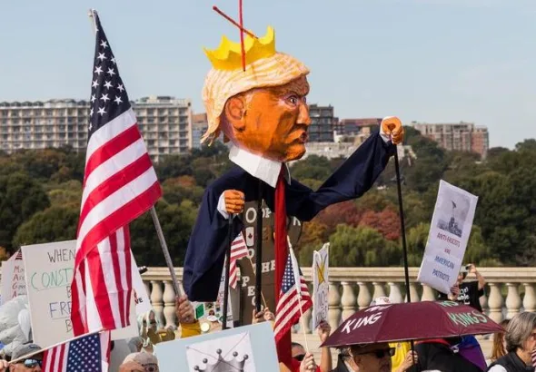 A "No Kings" protest in Washington D.C. on October 18, 2025, that was part of a larger series of nationwide protests against the US regime. The demonstration features an effigy of Donald Trump wearing a crown and a cape, carried by a protester. Photo: Tom Hudson/Zuma Press Wire/Shutterstock.