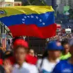 A big Venezuelan flag being waved by a marcher in Caracas demanding United Nations to prevent a US military aggression against Venezuela, October 6, 2025. File photo.