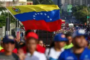 A big Venezuelan flag being waved by a marcher in Caracas demanding United Nations to prevent a US military aggression against Venezuela. October 6, 2025. Photo: file photo.