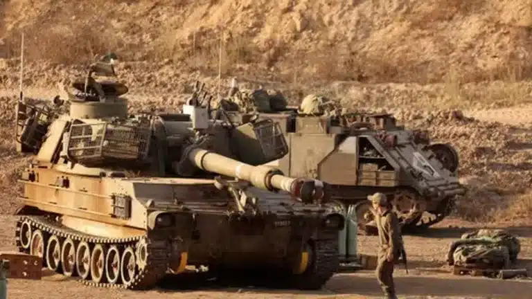 An Israeli trooper stands in front of a self-propelled howitzer stationed along the Gaza Strip’s border with the occupied Palestinian territories, September 30, 2025. Photo: AFP.