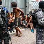 A photo from the operation showing detained individuals and police. Photo: EFE.