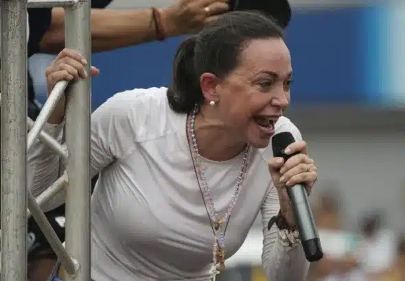 Venezuelan opposition leader María Corina Machado speaks into a microphone at a public event. Photo: Codepink.