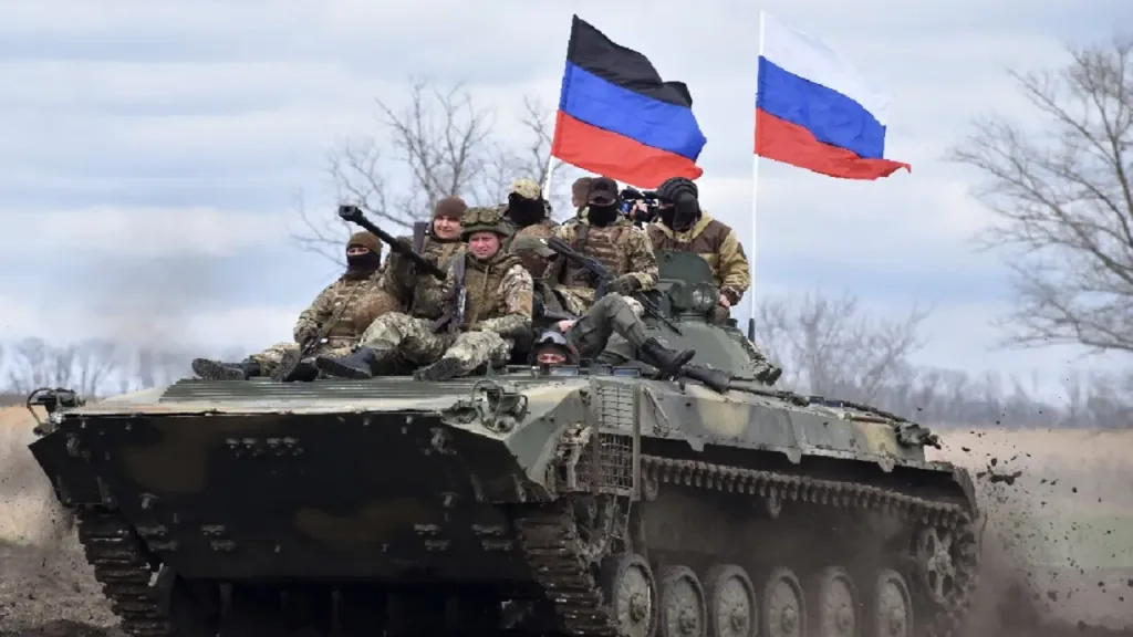 Soldiers on an armored personnel carrier (APC) carrying the flag of the Russian Federation and the flag of the Donetsk People's Republic. Photo: New Eastern Outlook.