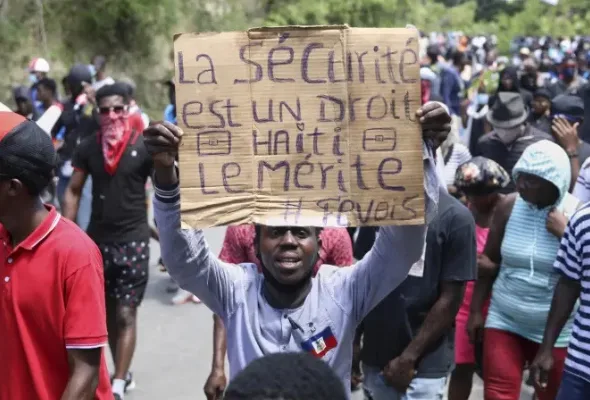 A protester holds up a sign that reads in French, "Security is a right, Haiti deserves it" during a demonstration in Port-au-Prince, Haiti, April 2, 2025. Photo: Odelyn Joseph/AP.