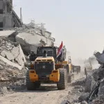 A digger which has been supplied by Egypt, drives past destroyed buildings as the search for the bodies of Palestinians resumes, in Gaza City on November 2, 2025. Photo: AFP.
