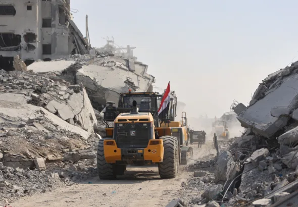 A digger which has been supplied by Egypt, drives past destroyed buildings as the search for the bodies of Palestinians resumes, in Gaza City on November 2, 2025. Photo: AFP.
