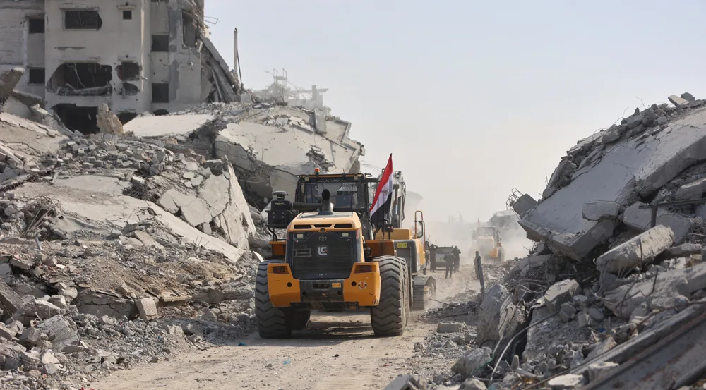 A digger which has been supplied by Egypt, drives past destroyed buildings as the search for the bodies of Palestinians resumes, in Gaza City on November 2, 2025. Photo: AFP.
