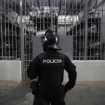 A guard looks at the detainees inside a cell in the Salvadoran mega-prison CECOT. Photo: EFE.