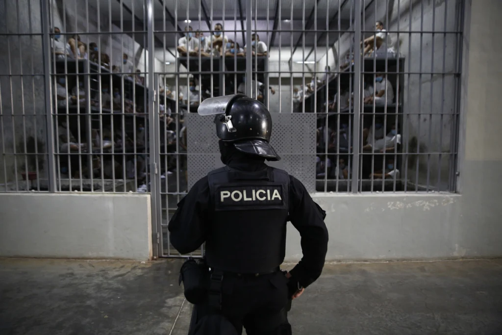 A guard looks at the detainees inside a cell in the Salvadoran mega-prison CECOT. Photo: EFE.