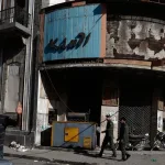 Three men walk through a street in the old city of Homs, Syria. Photo: AP.