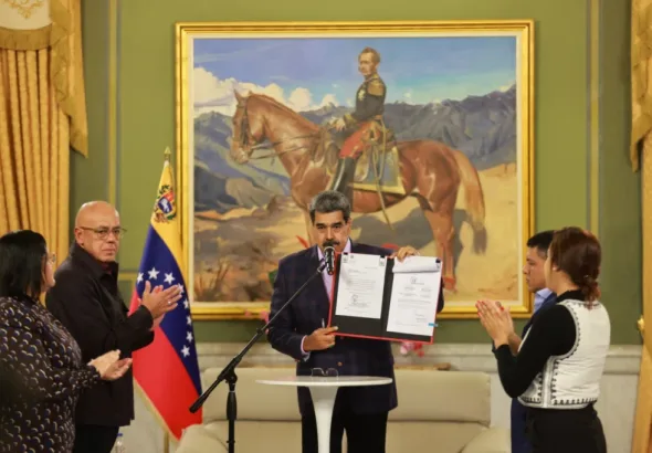 Venezuelan President Nicolás Maduro holds up the signed Law of the Command for the Integral Defense of the Nation, in Miraflores Palace, Caracas, November 11, 2025. Photo: Con El Mazo Dando.