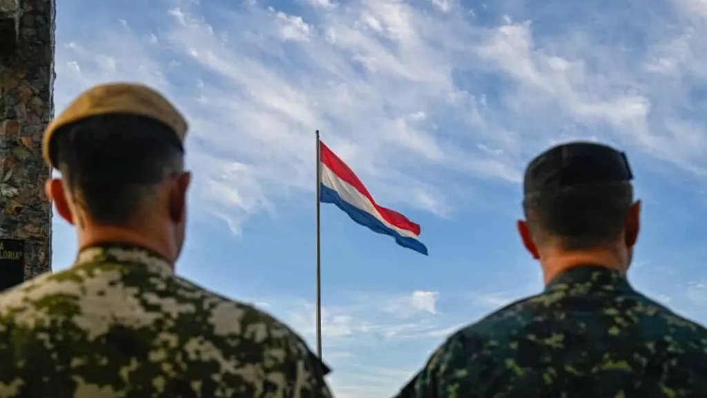 Two soldiers with the Paraguayan flag flying in the background. Photo: X/@Ejercito_Pyo.