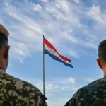Two soldiers with the Paraguayan flag flying in the background. Photo: X/@Ejercito_Pyo.