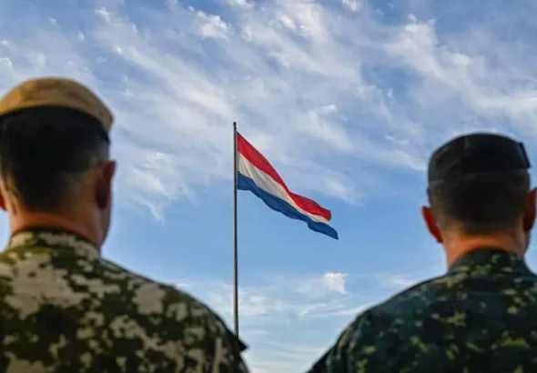 Two soldiers with the Paraguayan flag flying in the background. Photo: X/@Ejercito_Pyo.