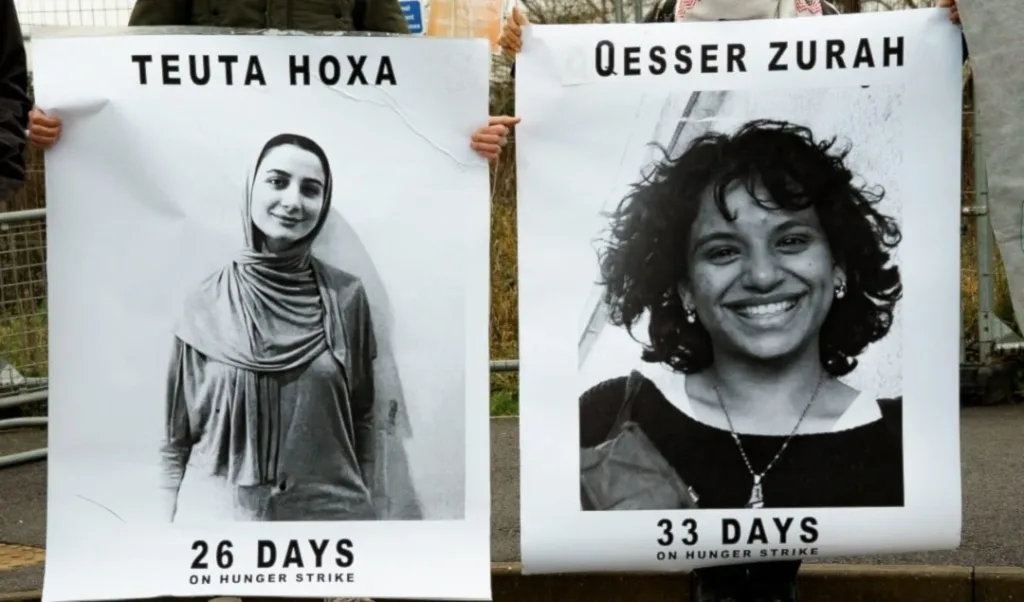 The image shows posters of Teuta Hoxha and Qesser Zurah (also spelled Qesser Zuhrah), who are activists affiliated with Palestine Action and have been on a prolonged hunger strike in UK prison. Photo: The Bristol Cable/file photo.