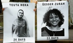 The image shows posters of Teuta Hoxha and Qesser Zurah (also spelled Qesser Zuhrah), who are activists affiliated with Palestine Action and have been on a prolonged hunger strike in UK prison. Photo: The Bristol Cable/file photo.