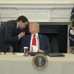 This image captures a moment during a White House roundtable event where Marco Rubio, the US Secretary of State, whispered in President Donald Trump's ear after handing him a note. October 2025. Photo: Screenshot of White House footage.