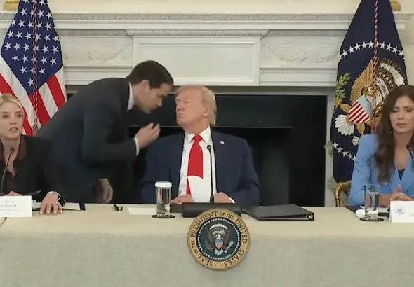 This image captures a moment during a White House roundtable event where Marco Rubio, the US Secretary of State, whispered in President Donald Trump's ear after handing him a note. October 2025. Photo: Screenshot of White House footage.