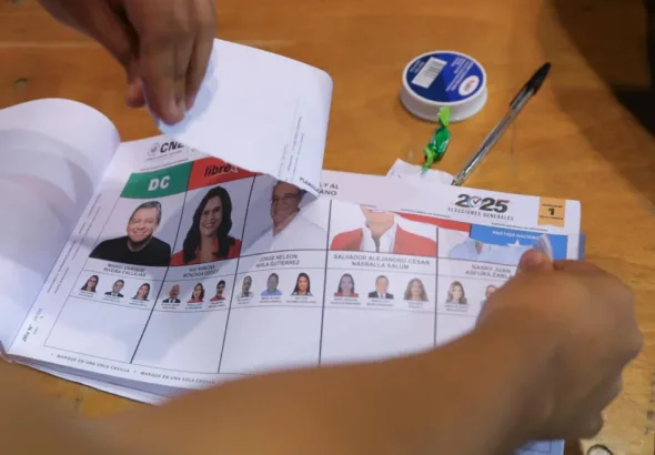 A polling station member tears up unused ballots after the end of voting in Honduras, November 30, 2025. Photo: EFE/Gustavo Amador.