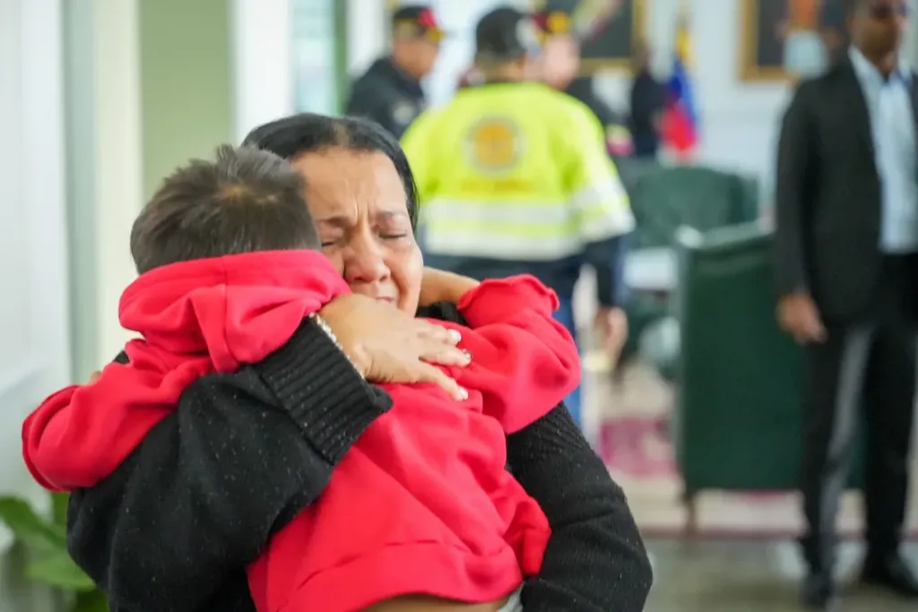 An emotionally shaken Venezuelan woman holds a child arriving in a repatriation flight from the US empire on Wednesday, November 26, 2025. Photo: IG/@vueltalapatria.