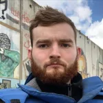 Robert Inlakesh in front of the separation wall at the Qalandia checkpoint, occupied West Bank, in February 2020. Photo: Robert Inlakesh/file photo.
