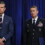 US Defense Secretary Pete Hegseth and Chairman of the Joint Chiefs of Staff Dan Caine listen as President Donald Trump addresses the media on January 3, 2026. Photo: Joe Raedle/Getty Images.