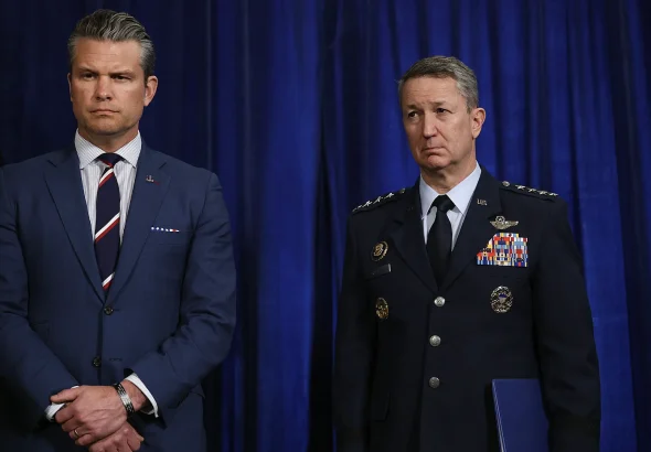 US Defense Secretary Pete Hegseth and Chairman of the Joint Chiefs of Staff Dan Caine listen as President Donald Trump addresses the media on January 3, 2026. Photo: Joe Raedle/Getty Images.