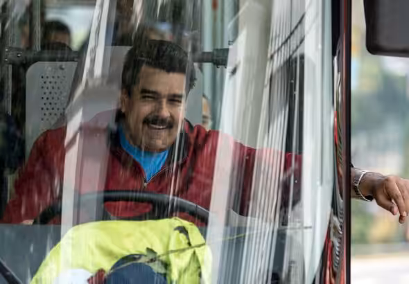 Venezuelan President Nicolas Maduro drives a bus while leaving the airport after arriving in Caracas, Venezuela, Jan. 17, 2015. Photo: AFP/file photo.