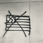 Graffiti in Mexico City showing a crossed-out US flag with a swastika. Photo: Camilo Ocampo.