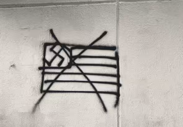 Graffiti in Mexico City showing a crossed-out US flag with a swastika. Photo: Camilo Ocampo.