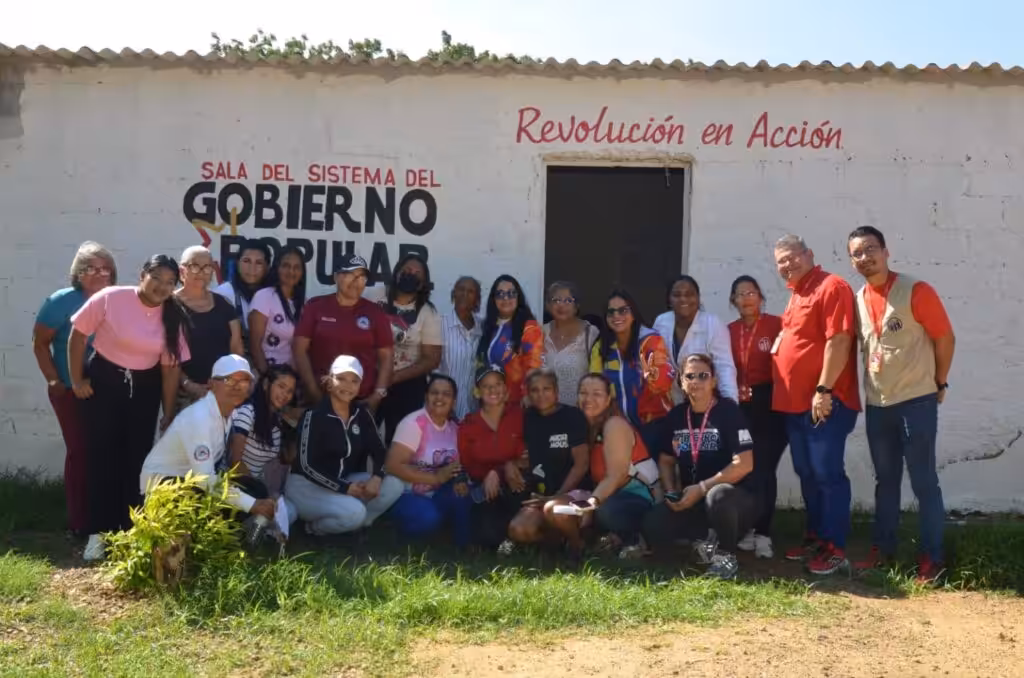 People pose for a photo in front of a building of the Revolución en Acción Commune, located in Miranda municipality of Falcón state, November 2025. Photo: Ministry of Popular Power for the Communes/Mincomunas Press Office.