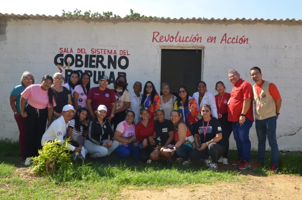 People pose for a photo in front of a building of the Revolución en Acción Commune, located in Miranda municipality of Falcón state, November 2025. Photo: Ministry of Popular Power for the Communes/Mincomunas Press Office.