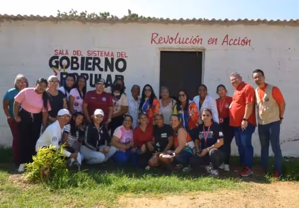People pose for a photo in front of a building of the Revolución en Acción Commune, located in Miranda municipality of Falcón state, November 2025. Photo: Ministry of Popular Power for the Communes/Mincomunas Press Office.