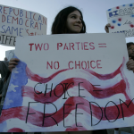 Cornell University student Marielle Newsome, of College Libertarians, holds in a demonstration a banner that reads “Two parties=No choice, Choice=Freedom, on Sept. 26, 2006, at Cornell University in Ithaca, NY. Photo: David Duprey/AP.