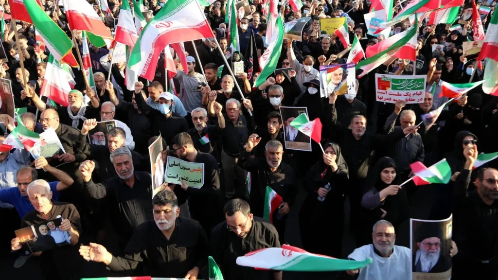 The image captures a pro-government rally in Iran,  held recently in response to ongoing US threats amid violent opposition protests. The participants, many dressed in black, are holding official Iranian flags and signs supporting the state and police. Photo: New Eastern Outlook.