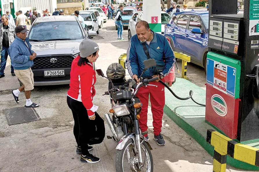 A driver refuels a motorcycle as other drivers wait in a long line at a petrol station in Havana, Cuba, Friday, January 30 2026. Photo: Morning Star.