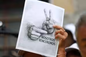 A Venezuelan woman holding, in a Jan. 28 demonstration, a sketch photo with the victory sign popularized by President Nicolas Maduro after being kidnapped by the US on Jan. 3, 2026. Photo: IG/@kimberly_meki.