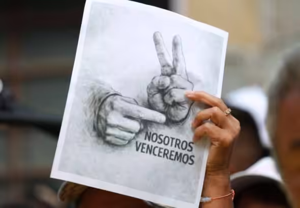 A Venezuelan woman holding, in a Jan. 28 demonstration, a sketch photo with the victory sign popularized by President Nicolas Maduro after being kidnapped by the US on Jan. 3, 2026. Photo: IG/@kimberly_meki.