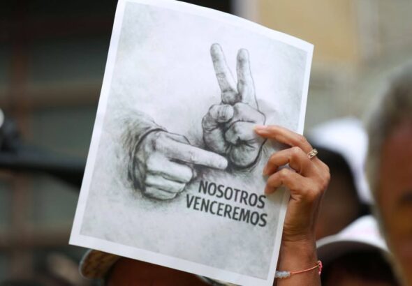 A Venezuelan woman holding, in a Jan. 28 demonstration, a sketch photo with the victory sign popularized by President Nicolas Maduro after being kidnapped by the US on Jan. 3, 2026. Photo: IG/@kimberly_meki.